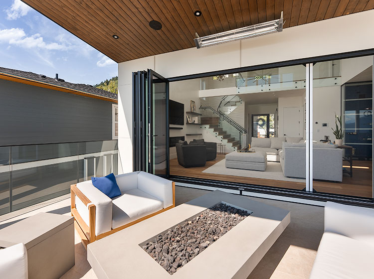 Modern patio with folding glass wall system opened to luxurious outdoor living space