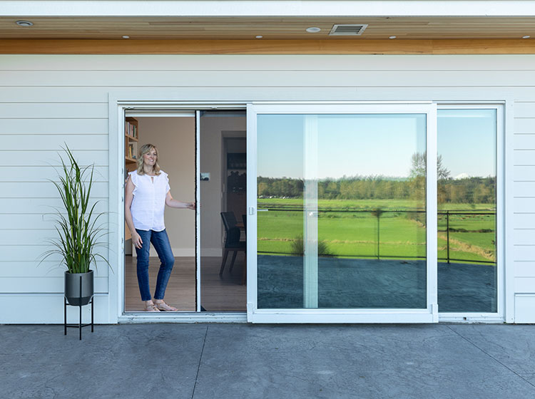 Large sliding glass doors with retractable screen and scenic green field view