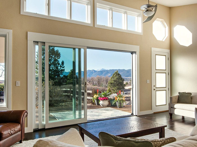 Bright living room with large multi-panel sliding glass door system and panoramic views