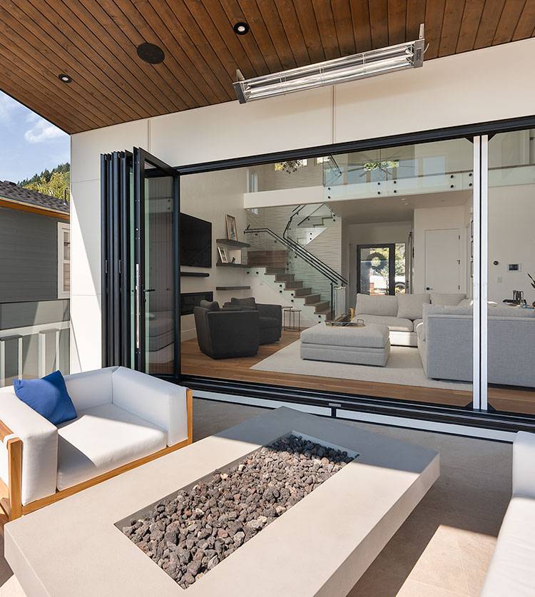 Covered patio with oversized retractable screens overlooking open green space